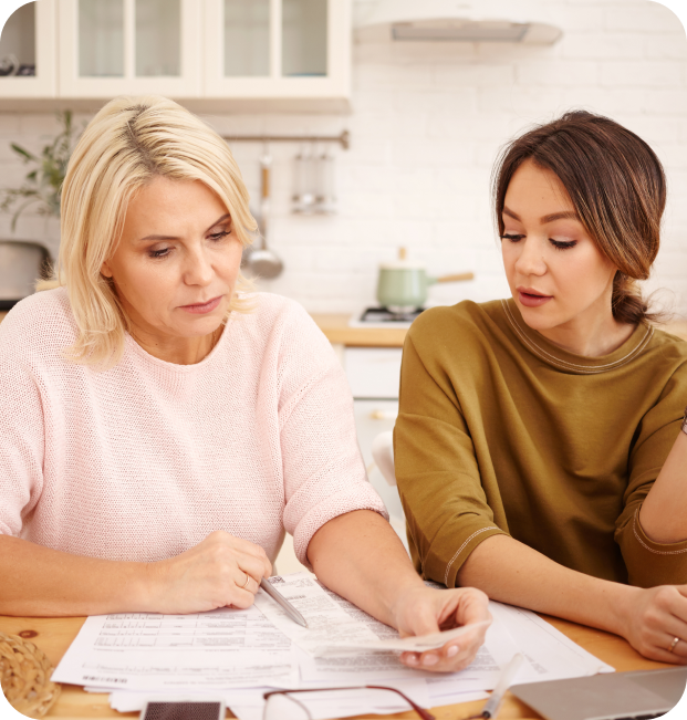 Two women discussing documents at a kitchen table